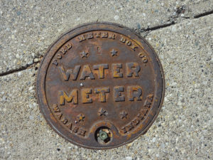 Picture of an old looking, cast iron water meter box